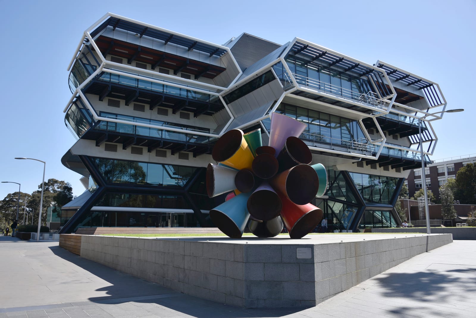 Chemistry teaching and Research Building at Monash University. Architect: Lyons 2015
Scupture - Built Unbuilt Unbuildable : James Angus. Commissioned by the Monash University Museum of Art (MUMA), Built Unbuilt Unbuildable was conceived by celebrated Australian artist James Angus. The structure of the work riffs off the cage-life fused-ring structure of the Buckminsterfullerene C60 carbon molecule, known colloquially as a ‘bucky ball’. Resembling a soccer ball, ‘bucky balls’ are considered one of the most stable of molecules because of their beautiful and intricate symmetry. In Angus’ artwork, the 'bucky ball' form has been appropriated and corrupted—instead of a shell like shape, the spherical structure is constructed from a series of steel pipe cones protruding from a centre.

Inspired by its proximity to the Faculty of Science on Clayton campus, Built Unbuilt Unbuildable borrows from the architecture of the new Green Chemical Futures facility, and is intended to be a celebration of engineering, a discipline devoted to the invention of structures, systems, materials and processes.